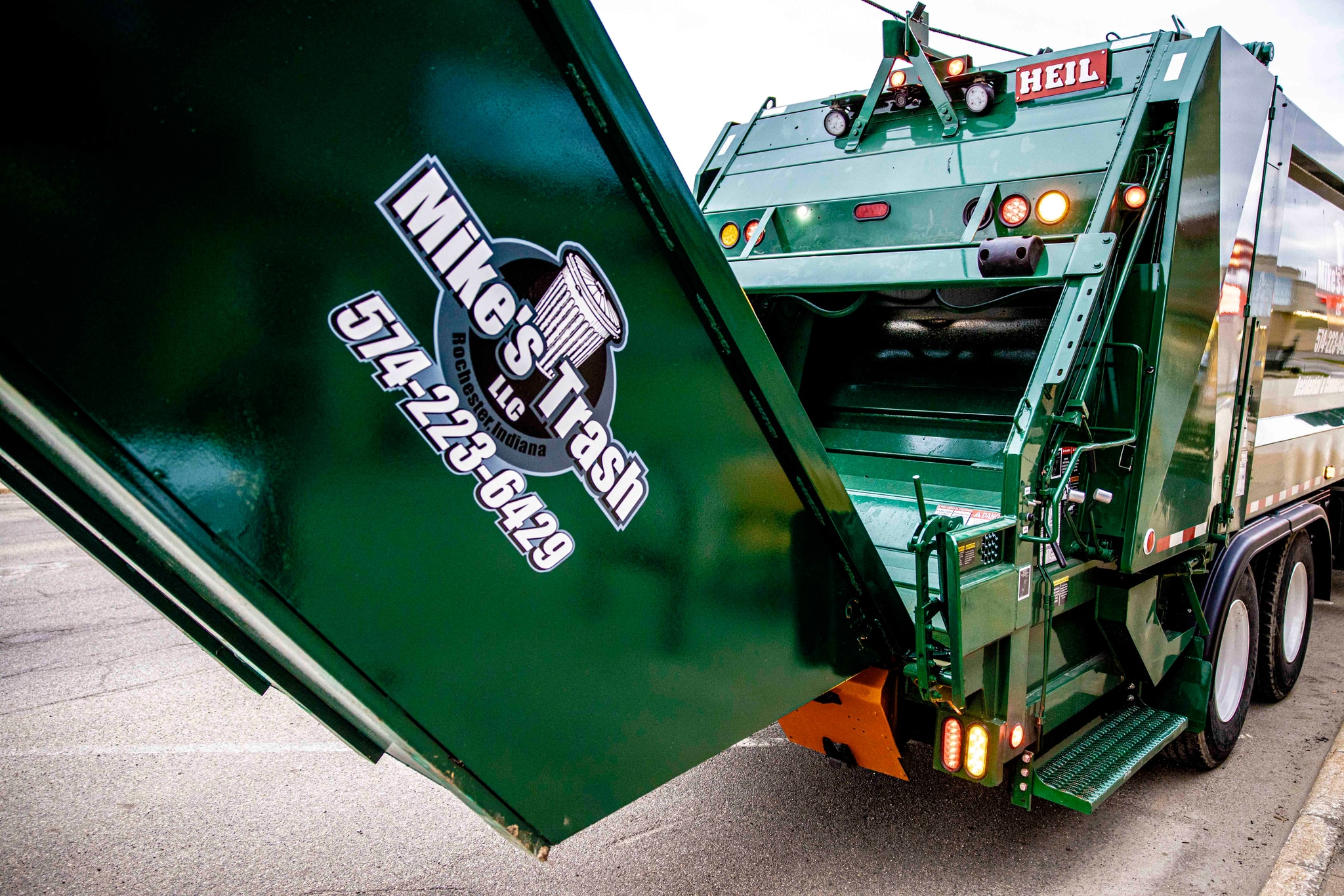 Mike's Trash truck emptying dumpster